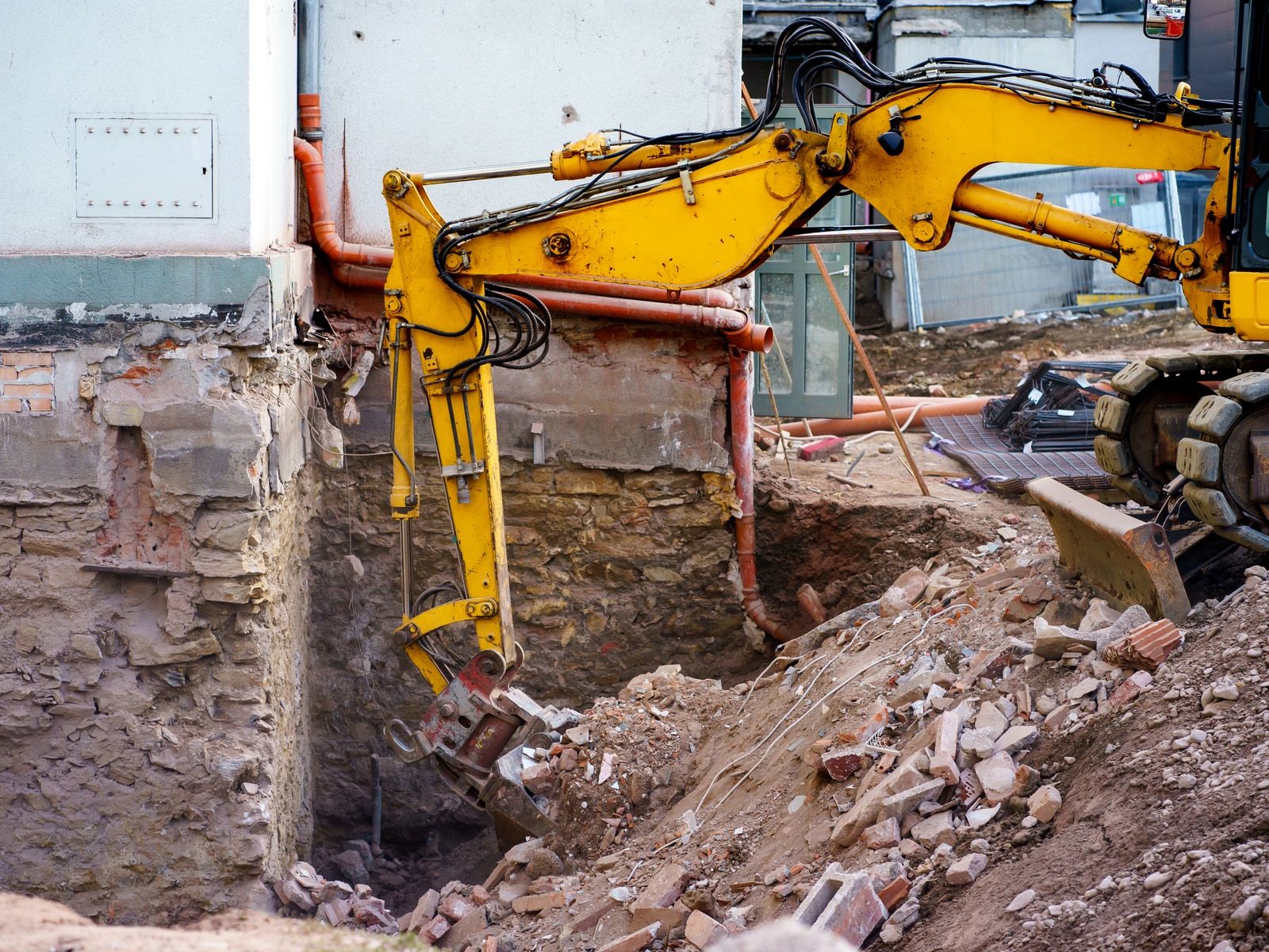 Excavadora demoliendo y retirando escombro en una obra